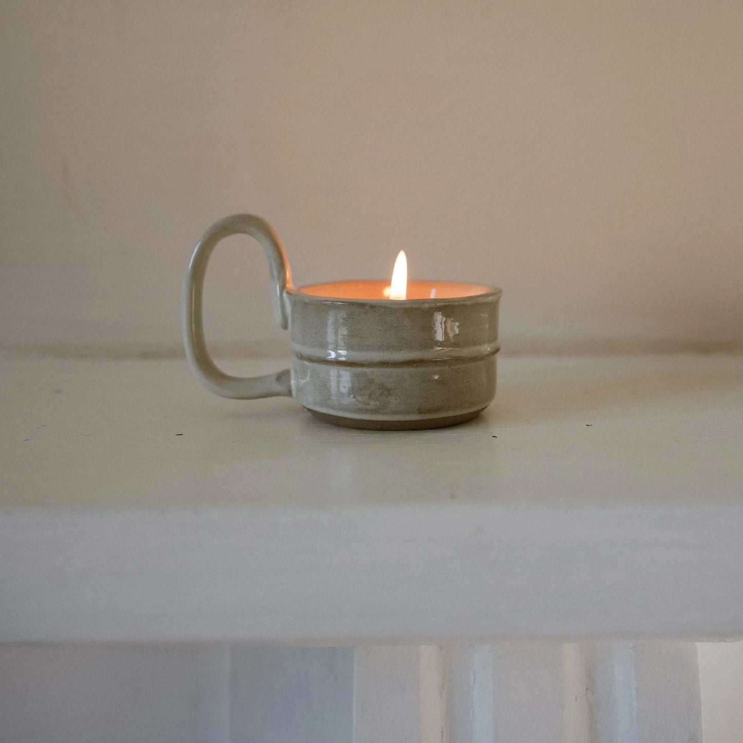 Hand crafted artisanal hand glazed ceramic tea light  holder designed for a small pillar or tea light candle but pictured with a lit tea light inside it. 