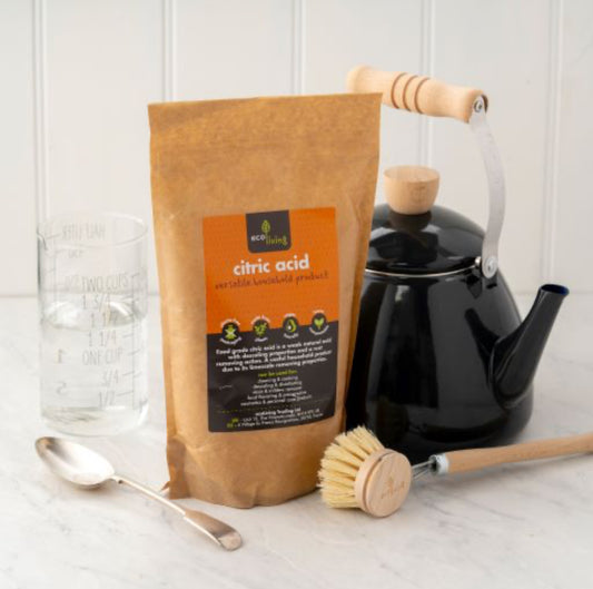 EcoLiving Citric Acid Pouch made from kraft brown paper positioned next to a traditional whistle kettle on a kitchen surface.