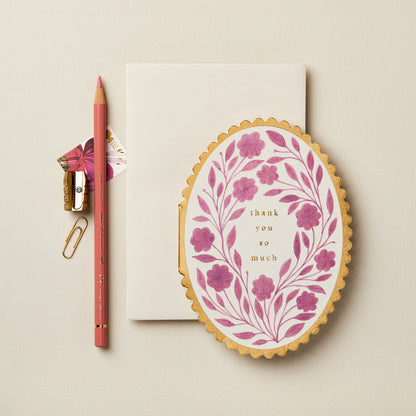 Floral card with 'thank you so much' text, pen, and paperclip on a beige background