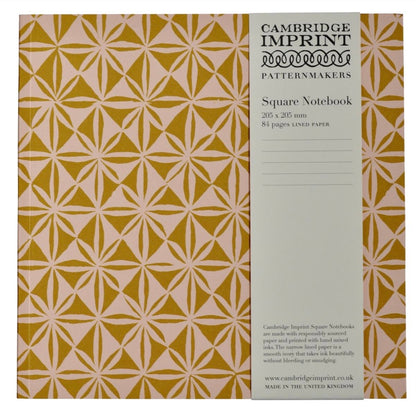 Cambridge Imprint patterned notebook with geometric design in pink and mustard with a paper belly band label describing the product. 