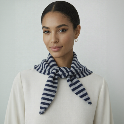 Model wearing a navy and white striped wool blend triangle neck scarf over a beige coat